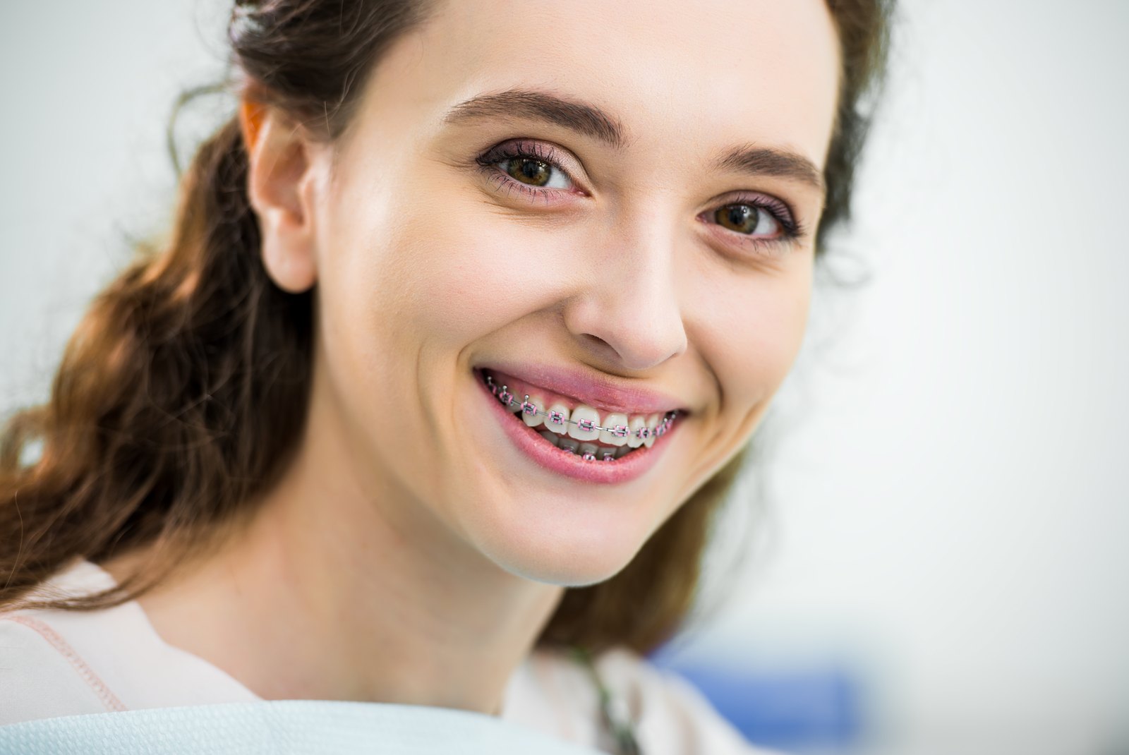 Mujer joven sonriendo con brackets metálicos