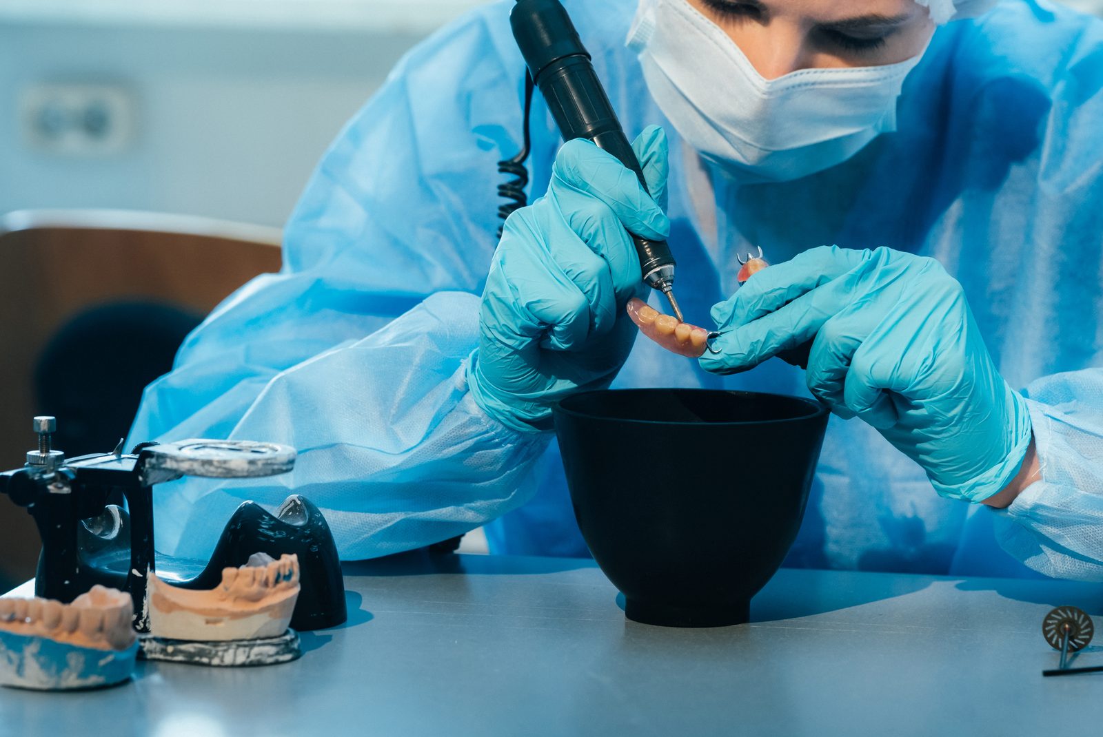 Protésico dental con guantes trabajando en una prótesis removible