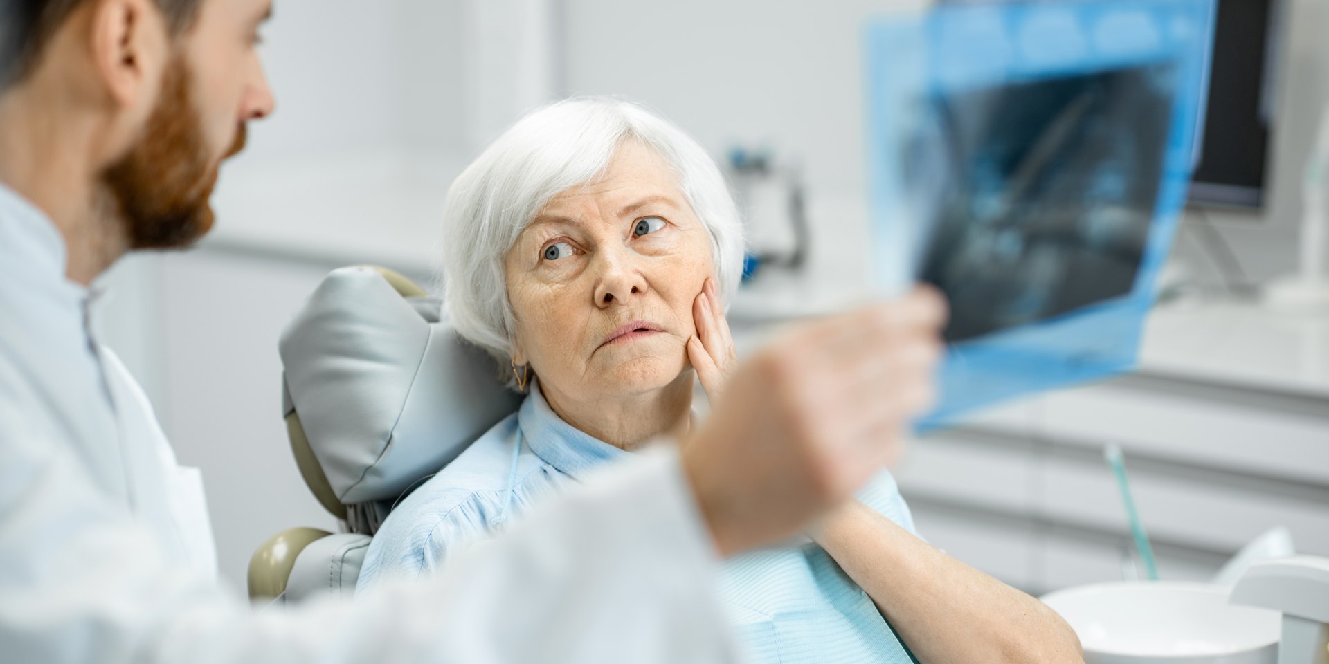 Dentista revisando una radiografía dental con su paciente en la consulta