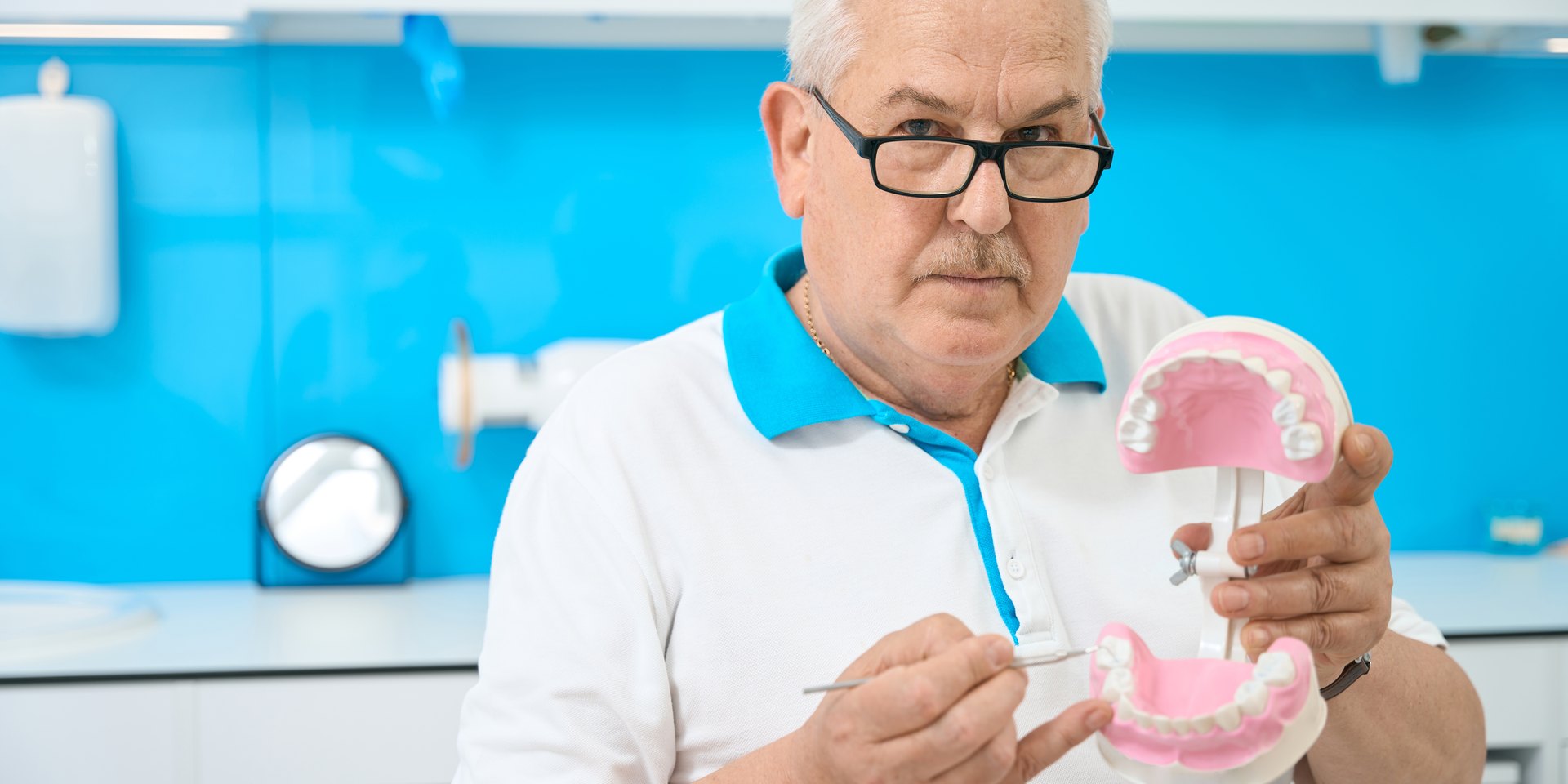 Ortodoncista revisando un modelo de dientes en su consulta