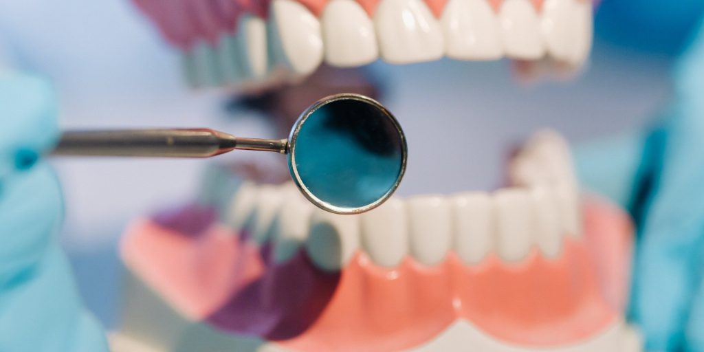 Espejo dental delante de un modelo de dentadura en la consulta de ortodoncia